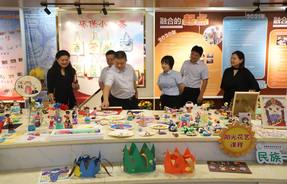 任慧校长（左一）介绍学校融合课程学生作品。